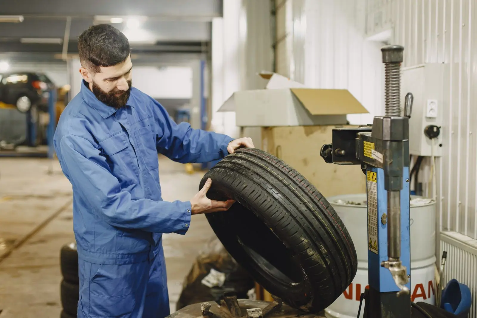 Técnico junto a una máquina para llantas. Imagen ilustrativa.